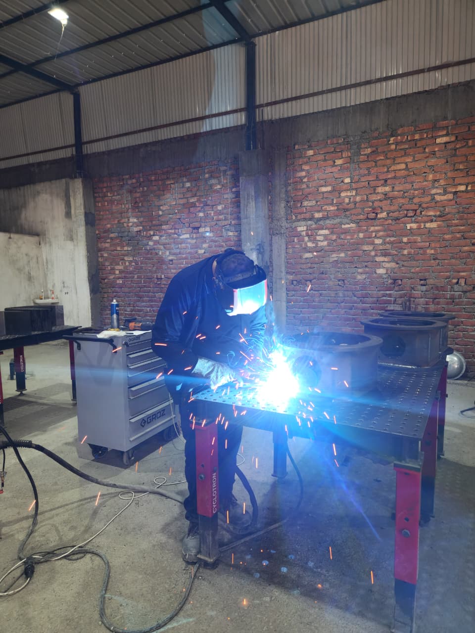 MIG welding with sparks on workshop floor